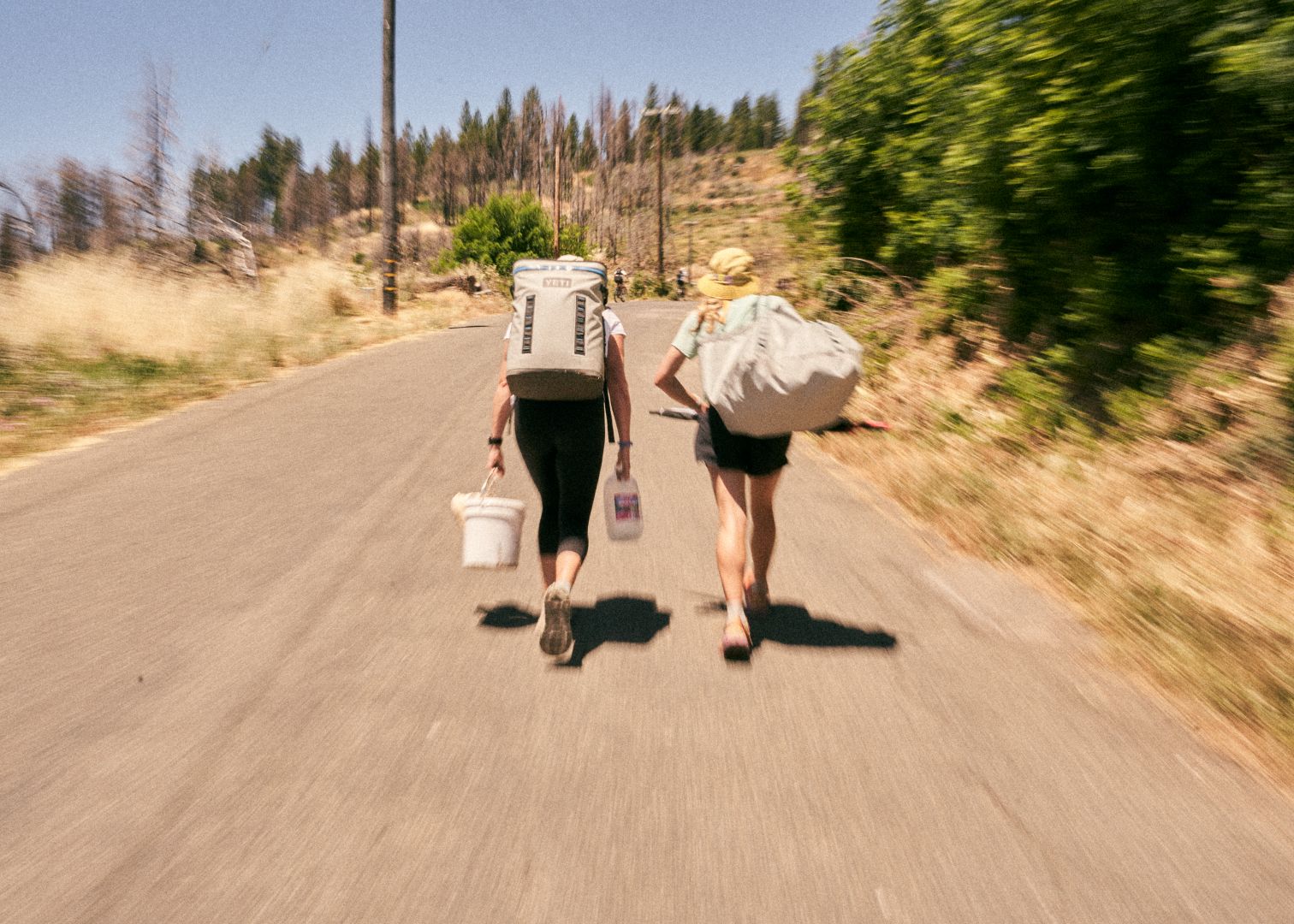Two people carrying gear